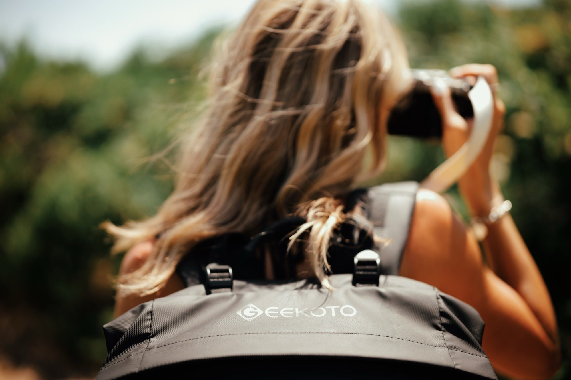 Geekoto ambassador Mandy Wright photographing outdoors while wearing a black Rogue camera backpack; photograph by Esteban Gil